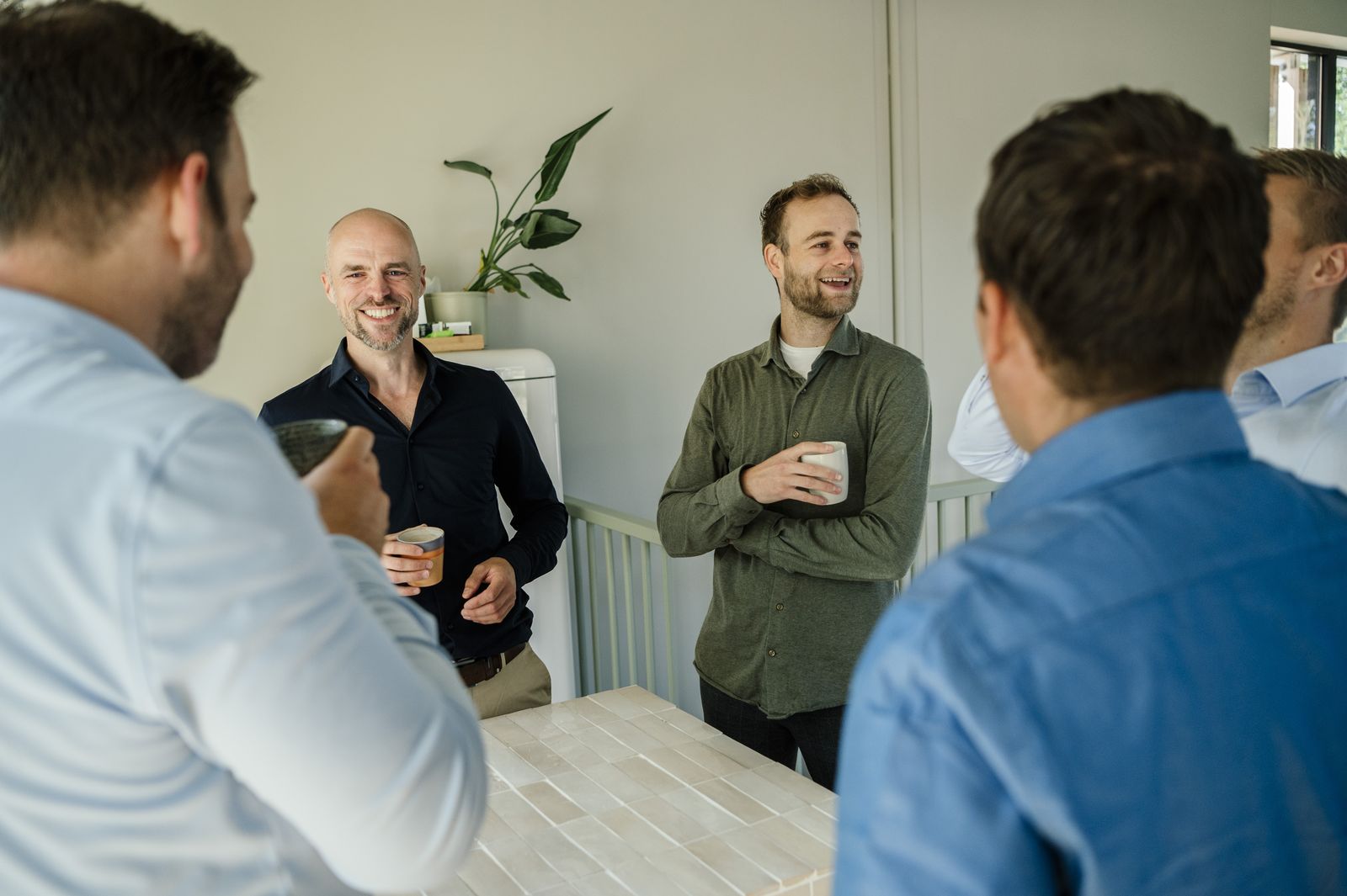 Collega's staan met koffie bij elkaar