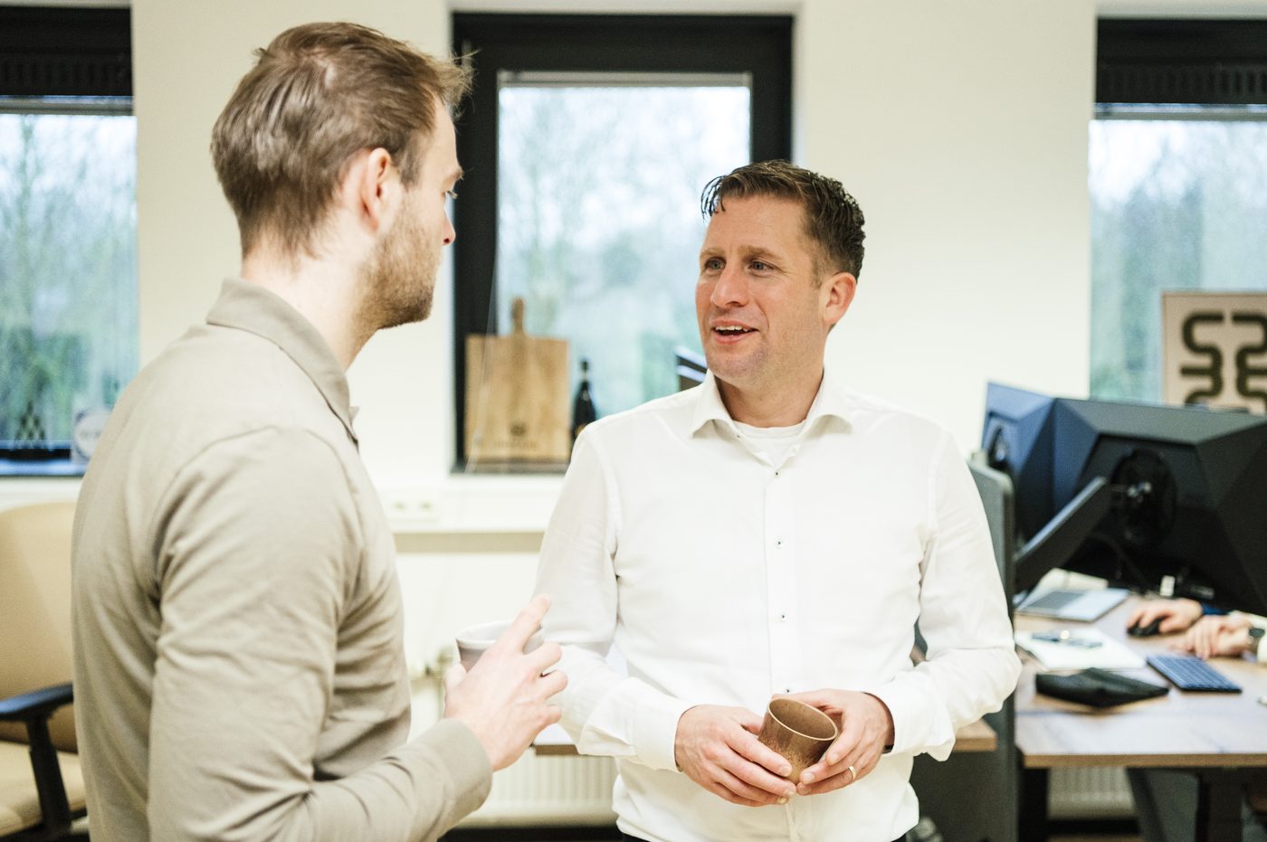 Twee collega's in gesprek met een kop koffie
