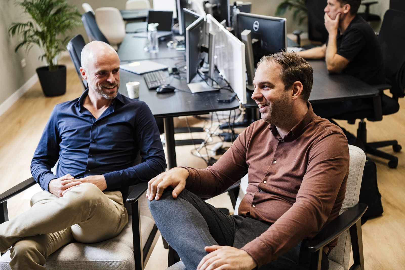 Twee collega's lachen samen in de zithoek