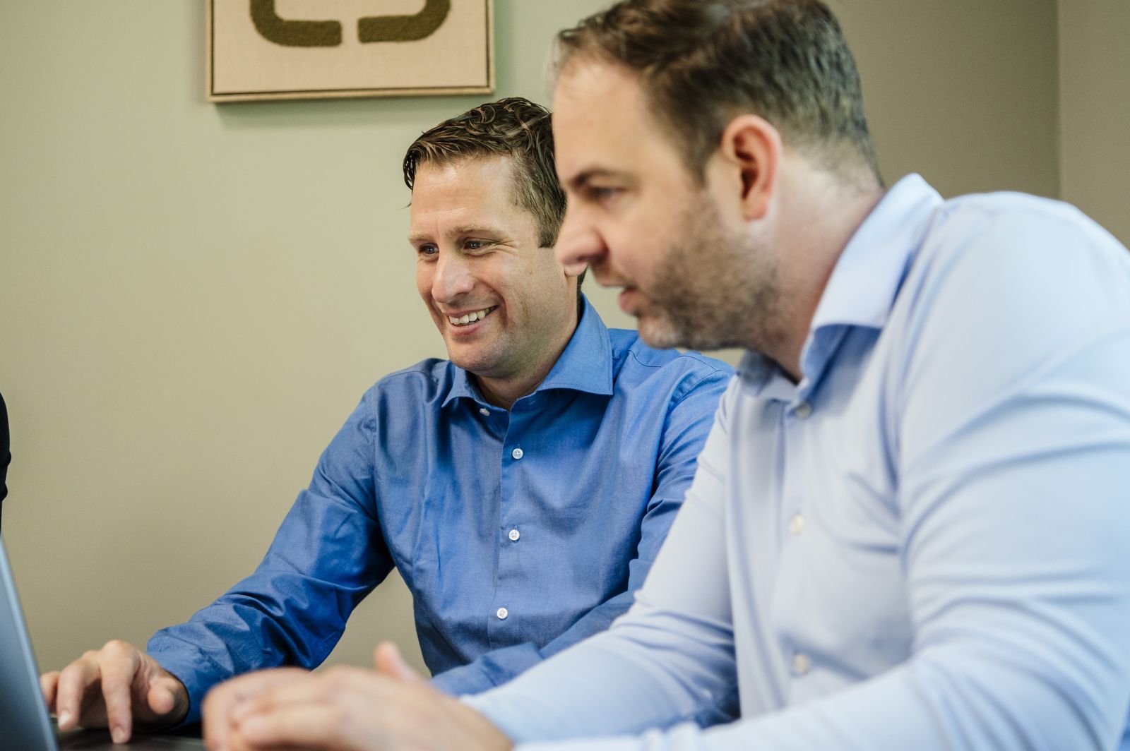 Twee consultants van Royaal kijken samen naar een scherm